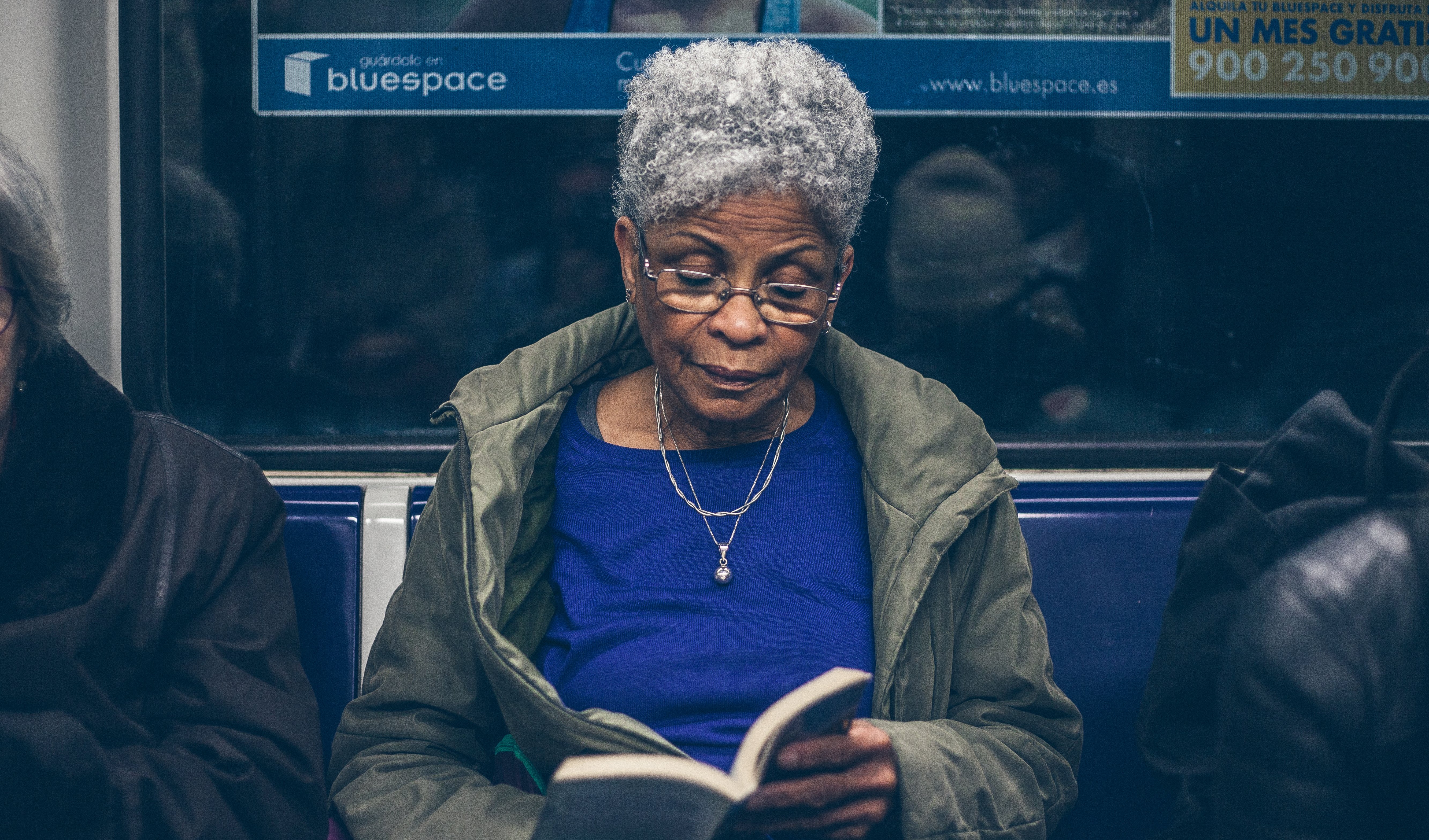 older-woman-reading-a-book-on-subway