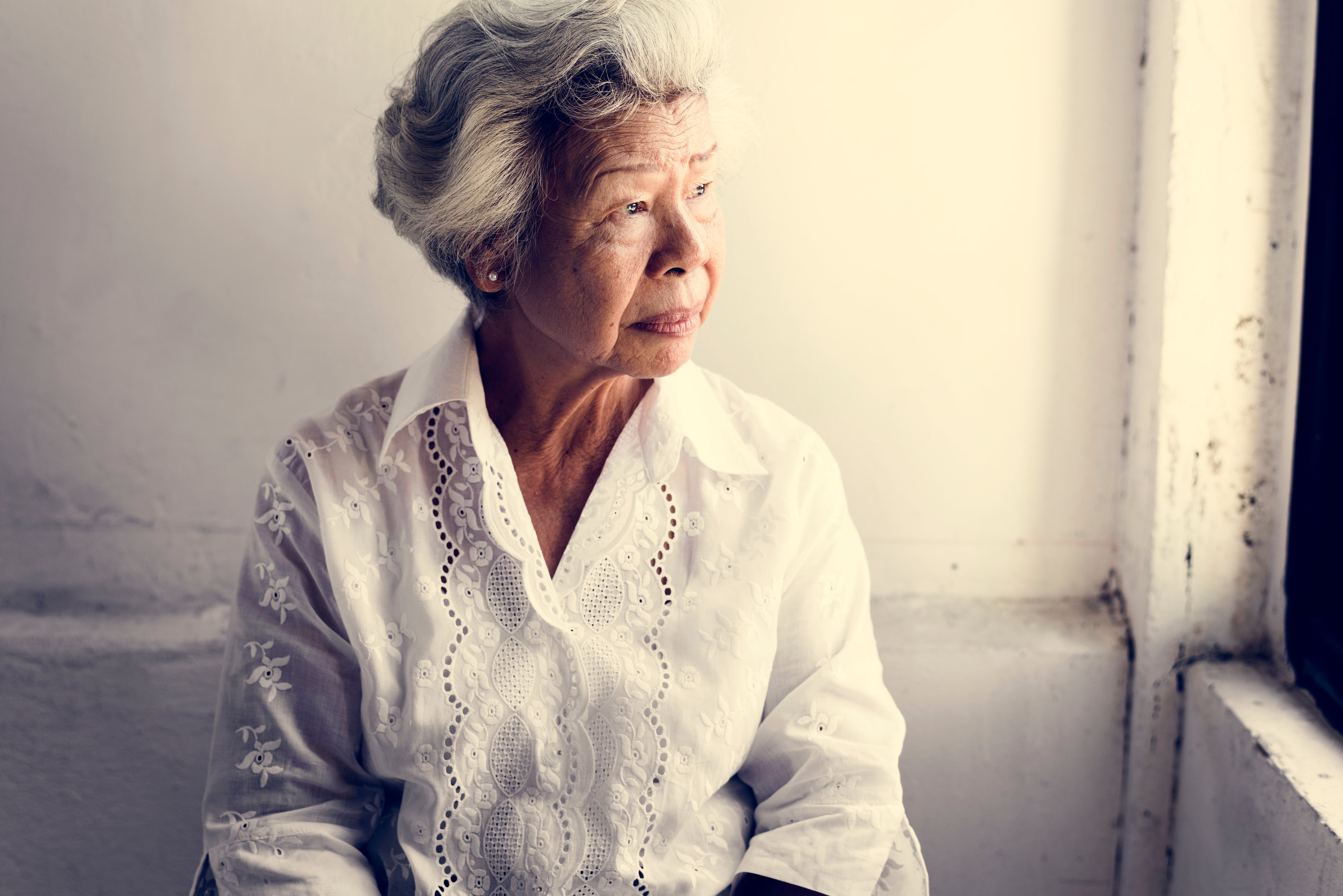 elderly-asian-woman-looking-out-of-the-window