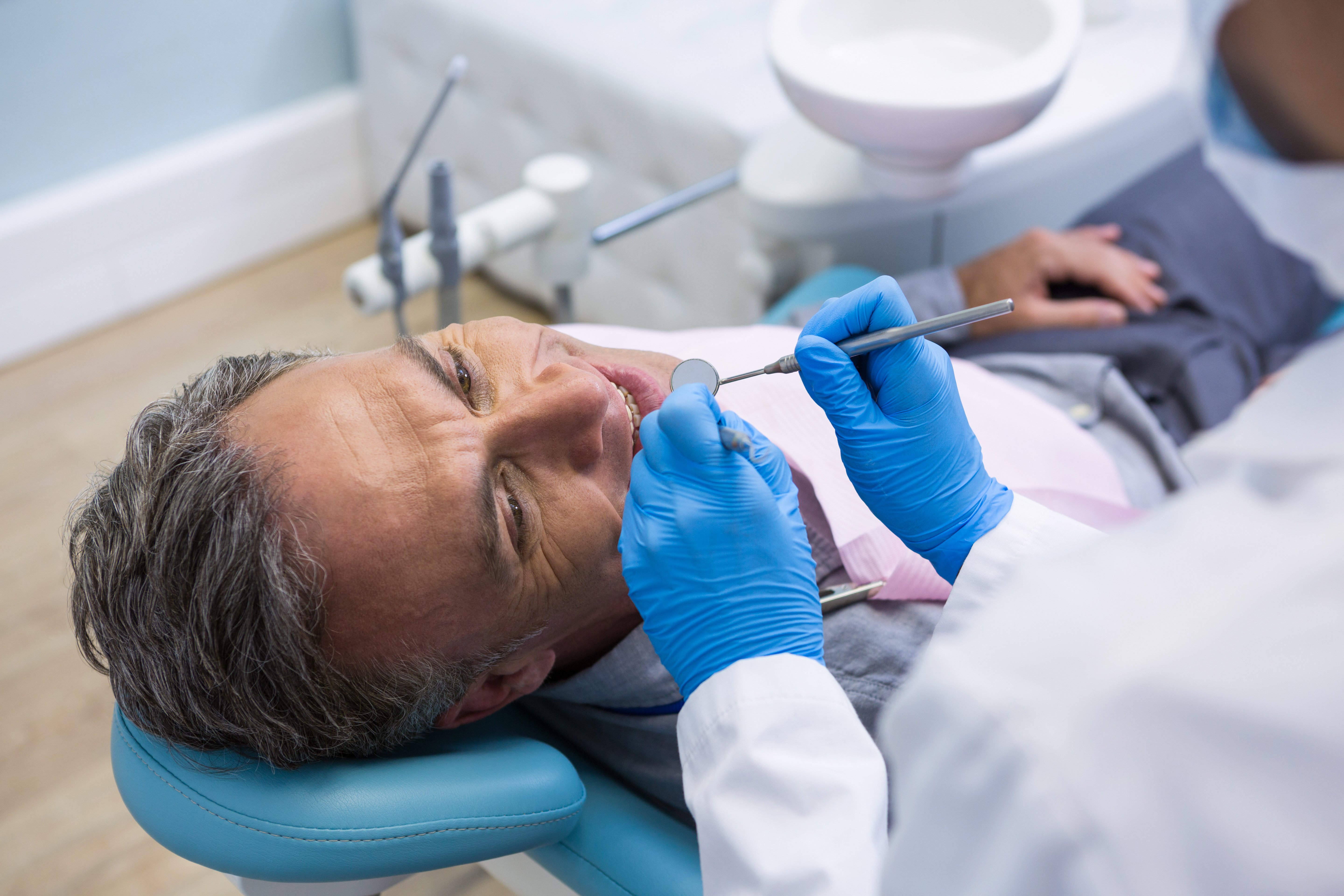 high-angle-view-of-dentist-examining-senior-man