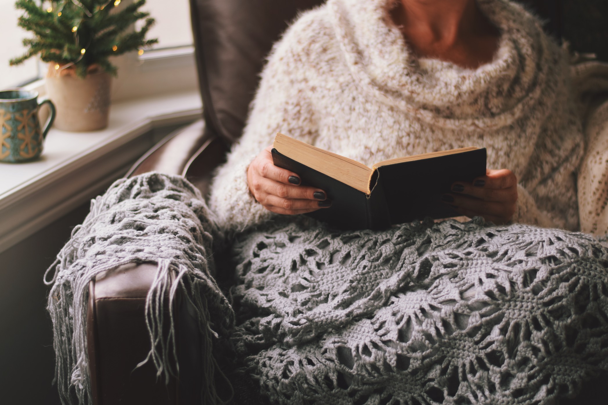 senior-woman-reading-and-looking-cozy-in-chair