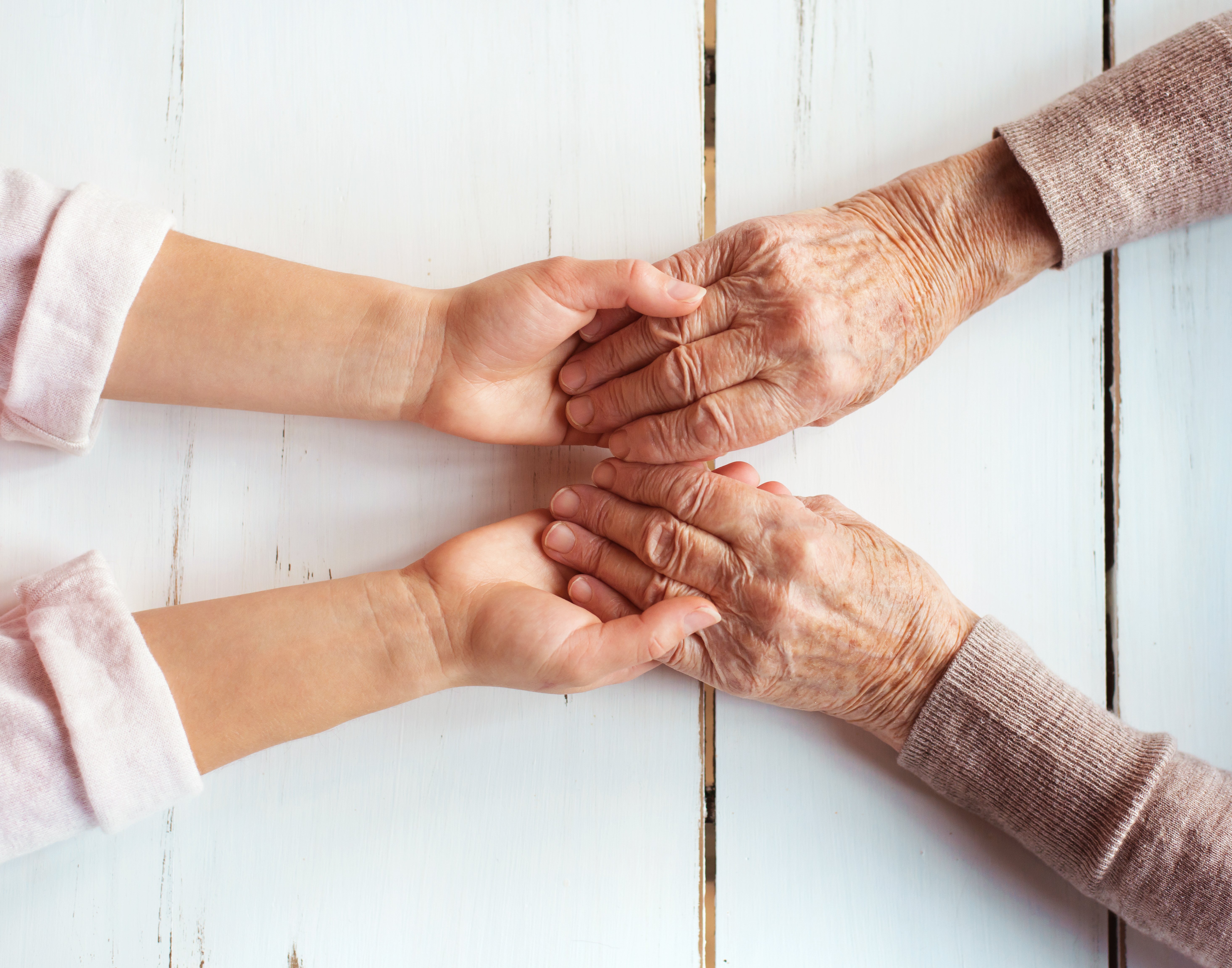 senior-woman-hands-holding-younger-hands